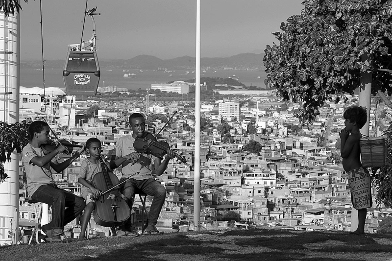 Menino observa ensaio dos irmãos Natanael, Gabriel e Gileard no Complexo do Alemão | Gustavo Miranda / O Globo