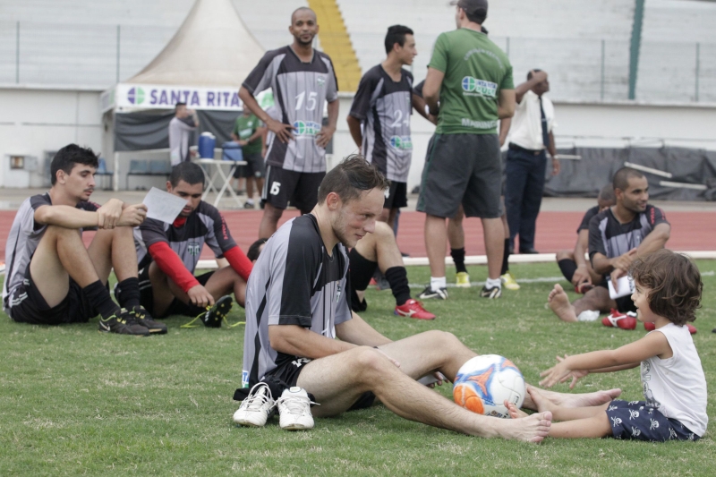 Treino descontraído do Maringá: o meio-campista Max brinca de bola com uma menina dentro do gramado | Ivan Amorin/ Gazeta do Povo
