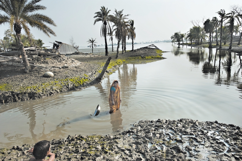 Bengalesa mostra lugar onde morava antes de uma tempestade, em 2009, deixá-la sem teto; cerca de 18 milhões de bengaleses podem perder suas casas em 40 anos | Kadir Van Lohuizen /The New York Times