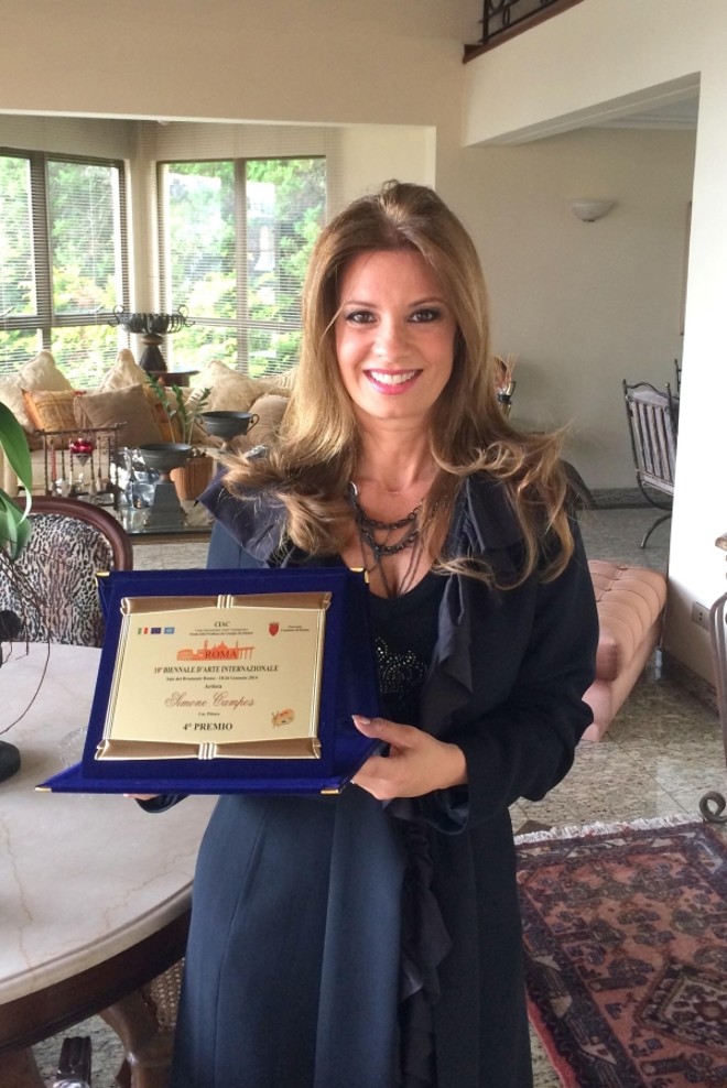 A artista plástica curitibana Simone Campos mostra o prêmio que ganhou na X Bienal Internacional de Roma pela obra