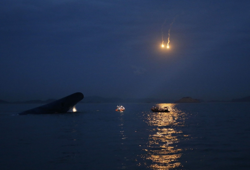 Sinalizadores iluminam a balsa sul-coreana Sewol emborcada, apenas com a ponta da quilha visível, durante operação de resgate. O motivo do acidente está sendo investigado | Kim Hong-Ji/Reuters