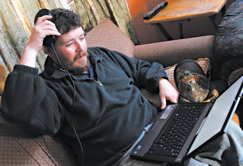 Kevin Ramsey baixando dados do dispositivo em seu cérebro que impede os ataques epiléticos, e permite que dirija e more sozinho | Herb Swanson para The New York Times