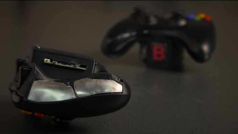 O aparelho desenvolvido por pesquisadores é um controlador manual Xbox 360 que teve a placa traseira retirada e acrescentado um módulo plástico impresso em 3-D e equipado com sensores. | Reprodução/YouTube.