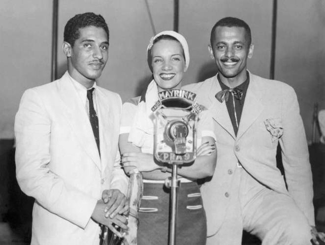 Caymmi ao lado da Pequena Notável, Carmen Miranda, cuja indumentária é descrita em 