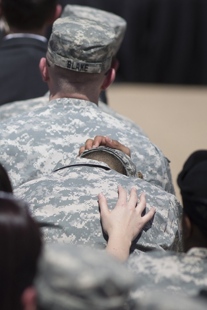 Homem é confortado por colega durante tributo | Julia Robinson/Reuters