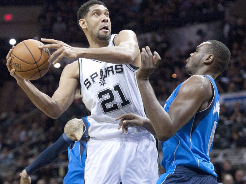 Tim Duncan encara marcação de Samuel Dalembert na vitória do Spurs sobre o Mavericks | Ashley Landis / EFE