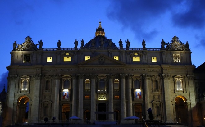Tapeçarias com imagens de João Paulo II e João XXIII adornam a Basílica de São Pedro, no coração do Vaticano, onde será realizada a cerimônia de canonização dos papas | Stefano Rellandini/Reuters