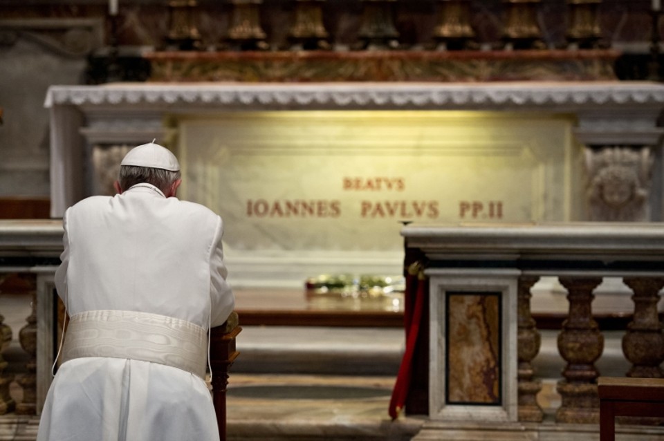 Canonização dos dois Joões é uma defesa da unidade na Igreja Católica Papa Francisco reza diante da tumba do papa João Paulo II na Basílica de São Pedro, no Vaticano. Para o vaticanista americano John Allen, sumo pontífice prega a união dentro da Igreja | LOsservatore Romano/Reuters
