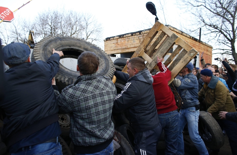 Manifestantes pró-Rússia constroem barricada em frente a uma base aérea em Kramatorsk, cidade do leste da Ucrânia | Marko Djurica/Reuters