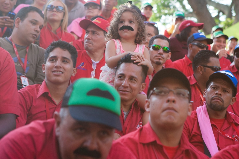 Manifestantes usam bonés com desenho de bigode, adereço que simboliza o apoio ao presidente venezuelano Nicolás Maduro | Miguel Gutiérrez/Efe