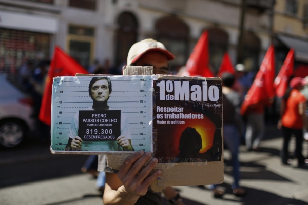 Em Lisboa, manifestante exibe uma montagem que mostra o primeiro-ministro português Passos Coelho detido, uma forma de protestar contra os altos índices de desemprego no país | Rafael Marchante/Reuters