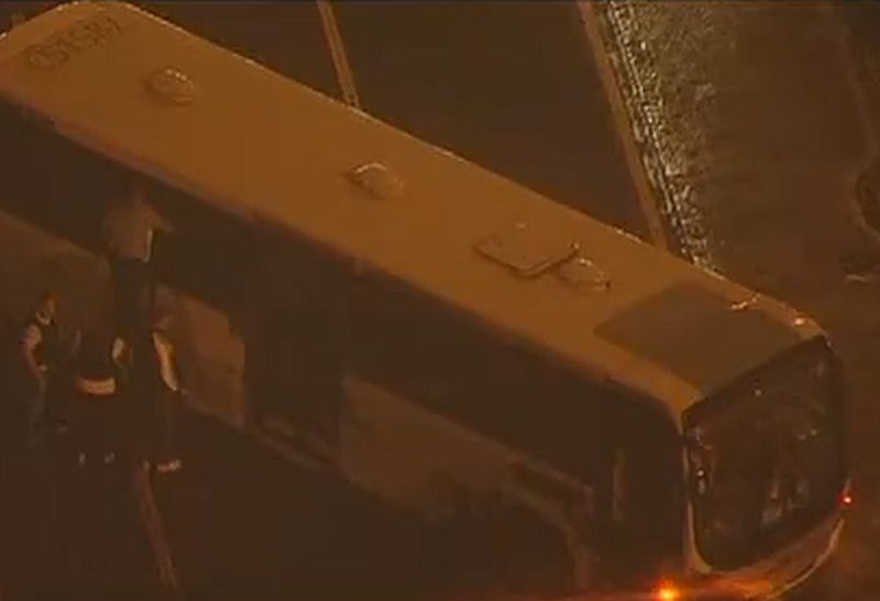 Policiais tentam negociar com assaltante. Ônibus está atravessado em uma das faixas de uma avenida movimentada | Reprodução/Globo News