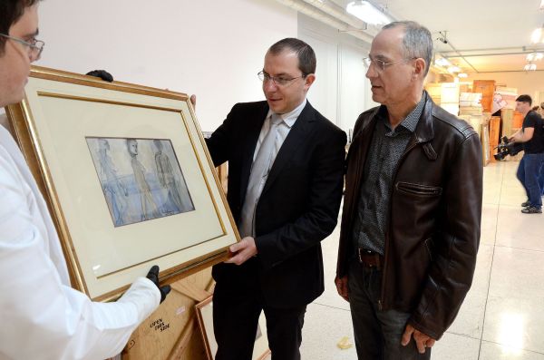 O delegado da Polícia Federal Marcio Adriano Anselmo (de gravata) mostra para o secretário da Cultura, Paulino Viapiana, quadro de Iberê Camargo, uma das obras de arte apreendidas pela operação Lava Jato e que ficarão sob a guarda do Museu Oscar Niemeyer | Kraw Penas