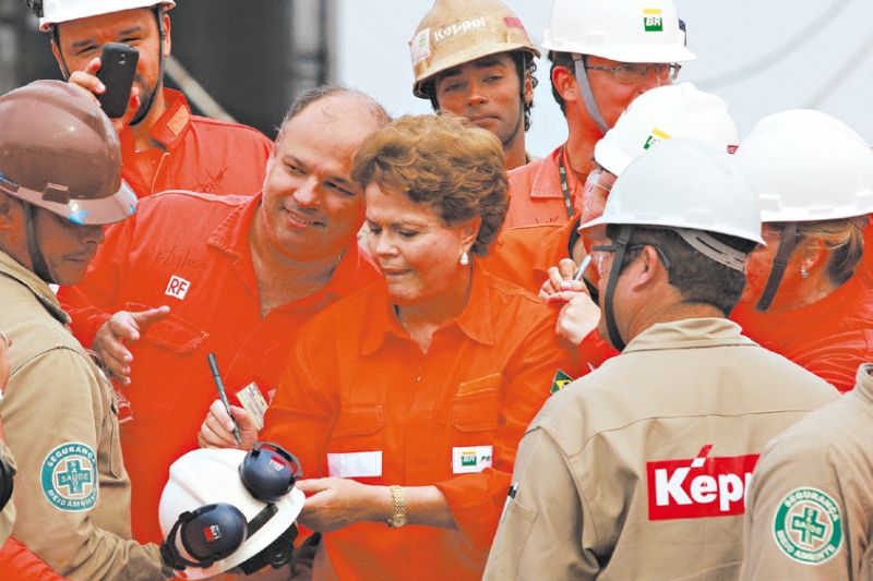 A presidente do Brasil, Dilma Rousseff, com operários da Petrobrás, impediu que a empresa aumentasse os preços | Ari Versiani/Agence France-Presse Getty Images