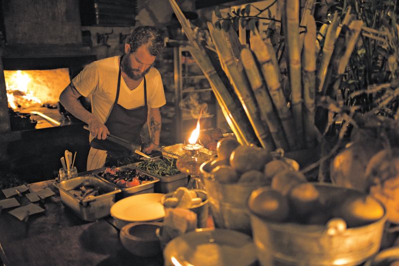 No Hartwood, em Tulum, o chef Eric Werner trabalha num fogão a lenha numa cozinha ao ar livre | Fotos: Adriana Zehbrauskas para The New York Times