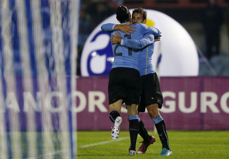 Stuani (de frente) é abraçado por Cavani após fazer o gol da vitória uruguaia diante da Irlanda do Norte | Andres Stapff / Reuters