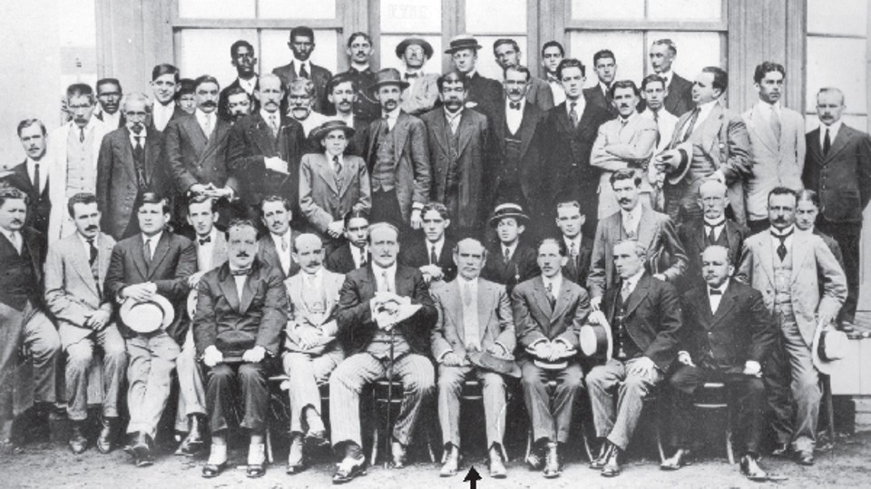 Fotografia do grupo que compunha a Companhia de Melhoramentos de Curitiba, órgão criado por Cândido de Abreu, que aparece ao centro indicado pela seta. Na terceira fila, o baixinho de chapéu palheta é o engenheiro Fernando Eduardo Chaves, conhecido como Chavéco | Acervo Cid Destefani
