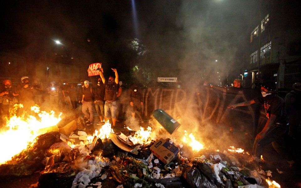 Manifestantes e PM entram em confronto em protesto contra gastos da Copa em SP Em resposta à ação da polícia, militantes fizeram barricadas com sacos de lixo | REUTERS/Paulo Whitaker