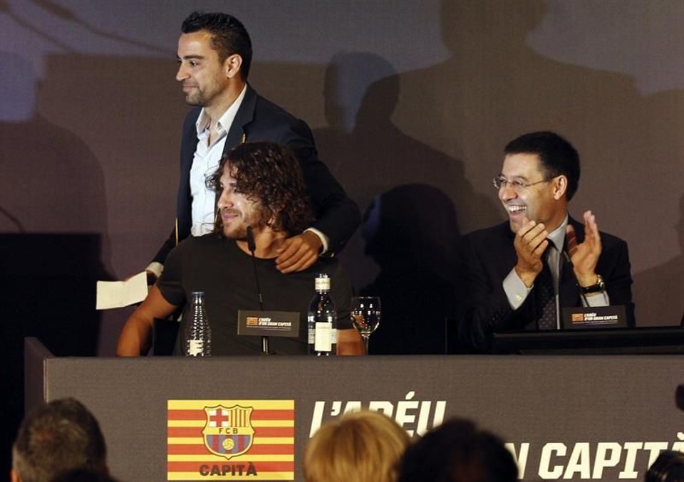 Puyol dá adeus emocionado ao Barcelona Carles Puyol, junto ao presidente do Barcelona, Josep María Bartomeu, e o meia Xavi Hernández. | Alejandro García/EFE