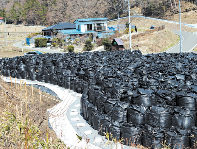 Sacos de resíduos contaminados por radiação são empilhados na estrada que leva a Miyakoji, que foi reaberta aos moradores | Ko Sasaki para The New York Times