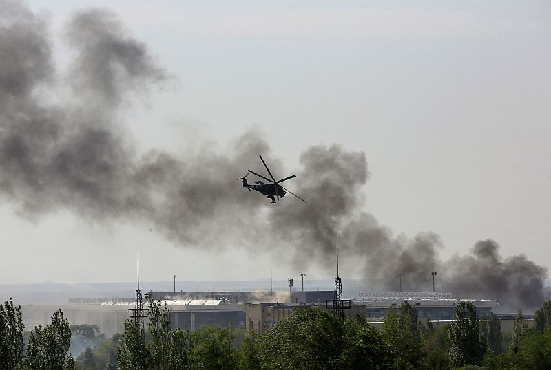 Helicóptero ucraniano dispara contra os rebeldes instalados no edifício principal do terminal do aeroporto internacional de Donetsk | REUTERS / Yannis Behrakis