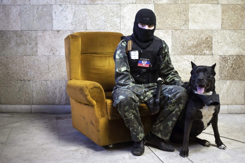 Ativista pró-Rússia com seu cachorro na prefeitura de Donetsk, tomada por insurgentes | Marko Djurica/Reuters