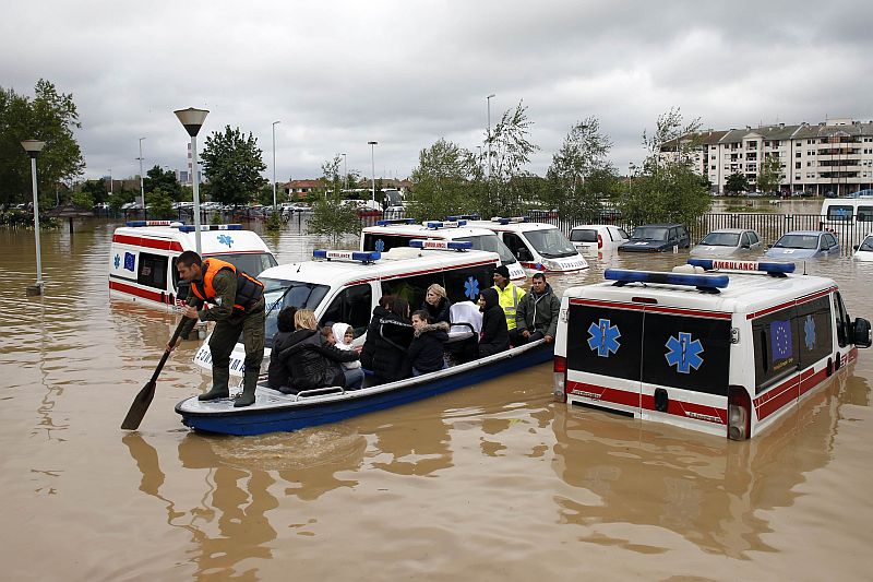 Barco resgata moradores e passa ao lado de veículos alagados em Obrenovac, na Sérvia | REUTERS/Marko Djurica