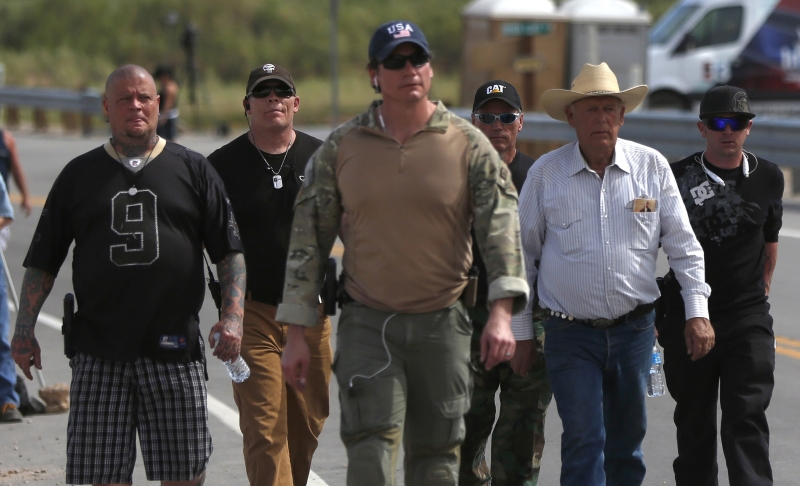 Cliven Bundy (à dir., de chapéu) é escoltado após ter cabeças de gado apreendidas | Jim Urquhart/Reuters