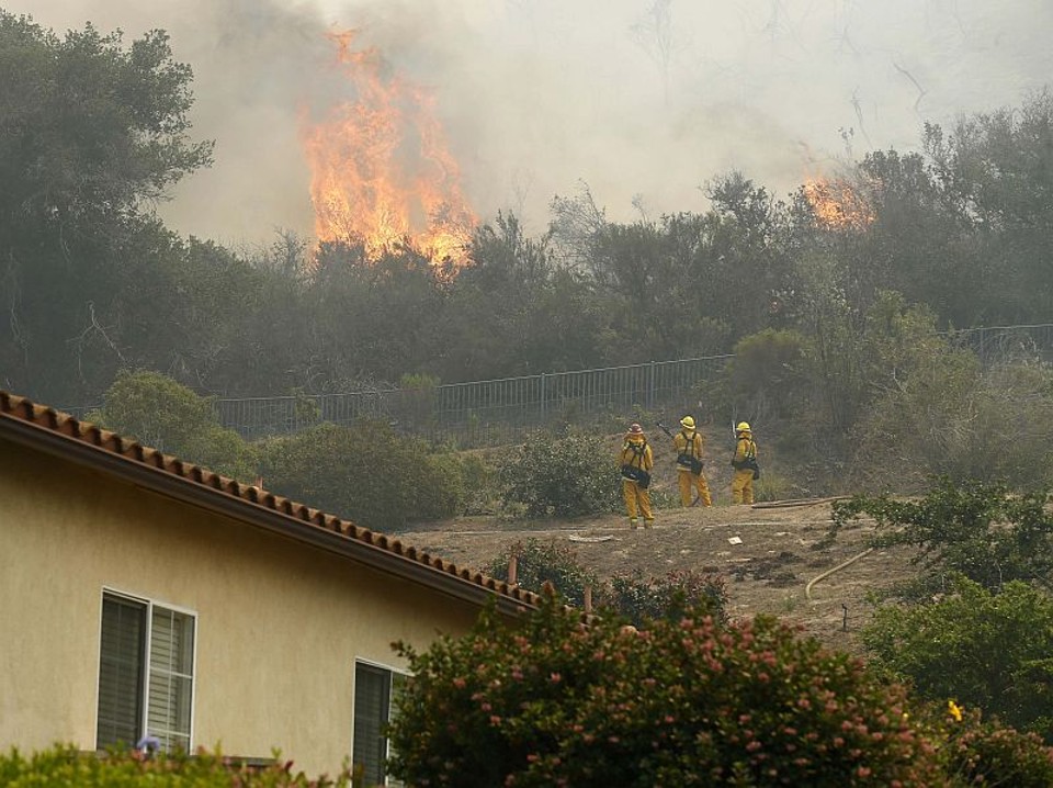 Incêndios forçam remoção de 20 mil no sul da Califórnia Bombeiros tentam conter incêndio em San Marcos, na Califórnia | REUTERS / Mike Blake