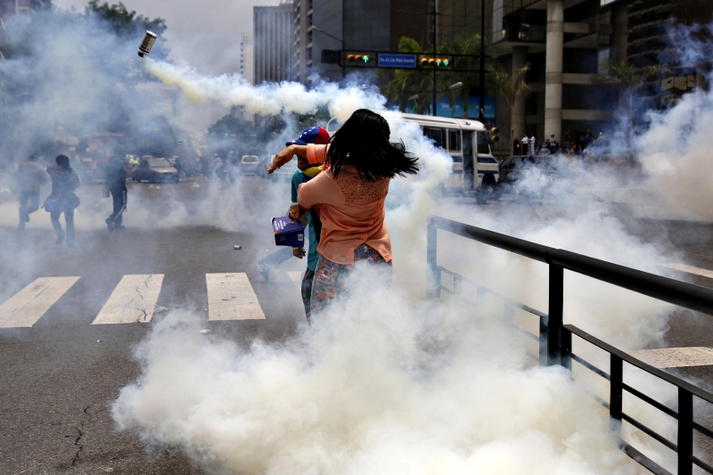 Manifestante devolve granada de gás para a polícia durante protesto contra o governo Maduro na capital venezuelana | Carlos Garcia Rawlins/Reuters