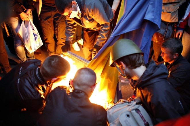 Manifestantes queimam bandeira da Ucrânia do lado de fora da prefeitura de Donetsk, no leste do país | Marko Djurica/ Reuters