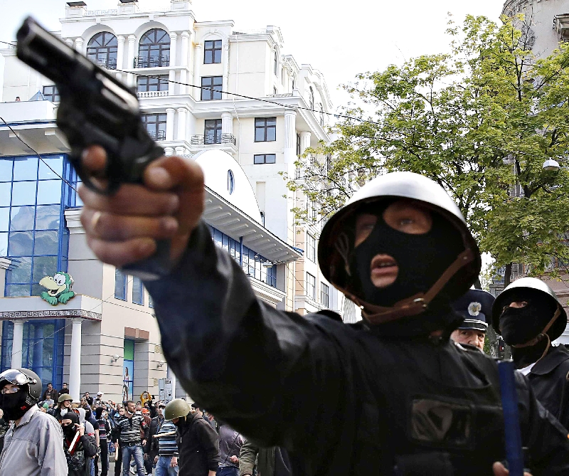 A ativista pró- russo aponta uma pistola para partidários do governo de Kiev em Odessa | Yevgeny Volokin/Reuters