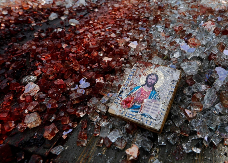 Na área do ataque, em Donetsk, imagem religiosa é encontrada entre cacos de vidro e sangue | Yannis Behrakis/Reuters