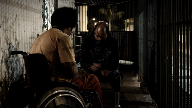 O DJ paraplégico Marquim, vivido por ele mesmo, e Shokito, que teve sua perna amputada, habitam uma cidade sitiada | Fotos: Divulgação