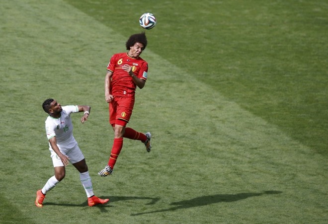 Jogador da Seleção Belga, Axel Witsel (dir.) pula para cabecear a bola |