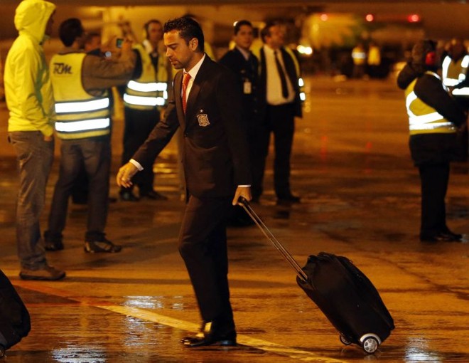 O meio-campo Xavi em meio a funcionários na pista do aeroporto |
