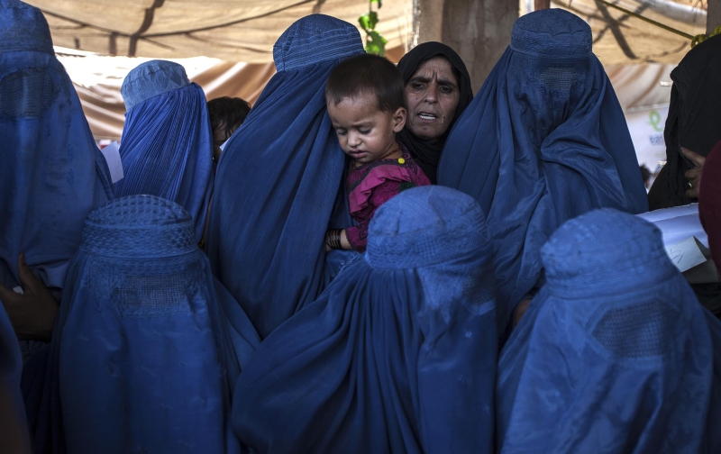 Mulheres e criança afegãs aguardam atendimento médico em clínica das Nações Unidas para refugiados, no Paquistão | Faisal Mahmood/Reuters