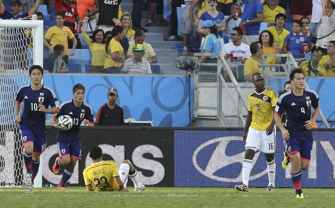 O meia japonês Shinji Okazaki (dir.) comemora após empatar o jogo contra a seleção colombiana |