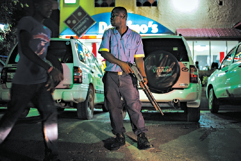 Segurança particular vigia pizzaria em Porto Príncipe, no Haiti | Ian Willms para The New York Times