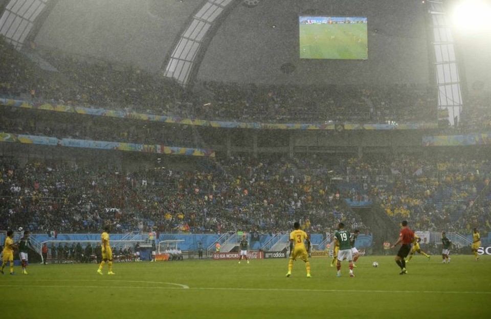 Uma forte chuva atingiu a Arena das Dunas durante a partida entre México e Camarões. As áreas cobertas do estádios não evitaram que torcedores e jornalistas se molhassem | REUTERS / Dylan Martinez