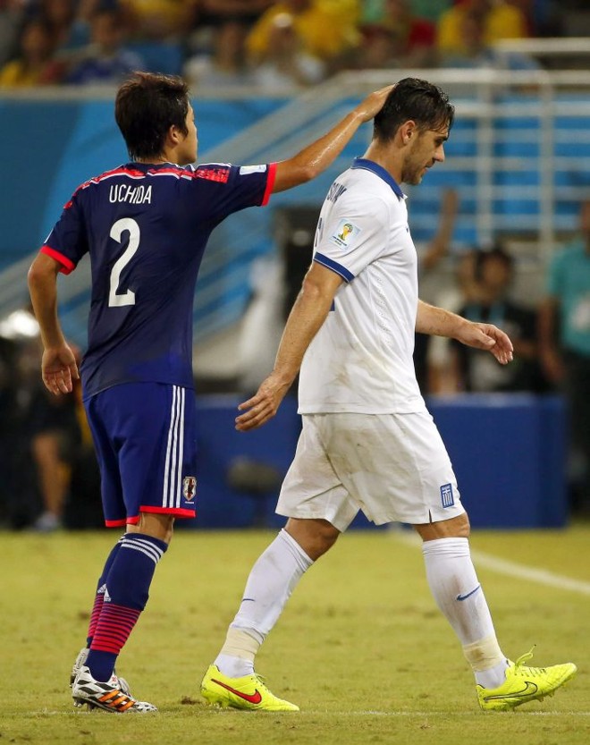 Konstantinos Katsourani, da Grécia, é consolado por Atsuto Uchida após a sua expulsão | 
