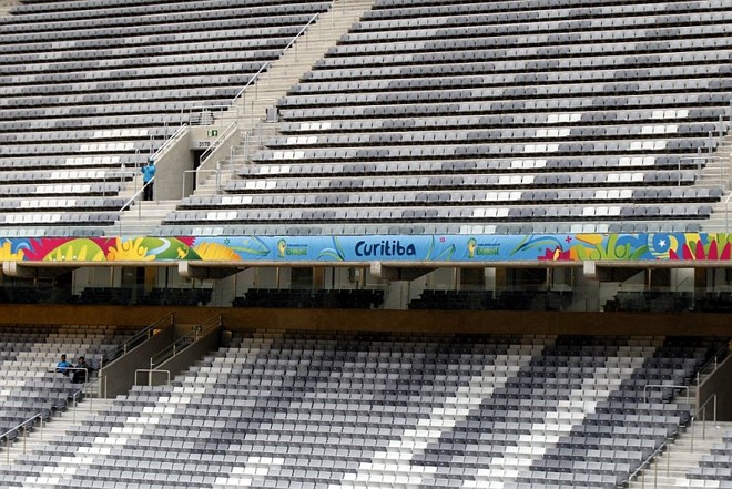 Os adesivos colados nos beirais do estádio têm as cores da Copa e o nome da cidade |