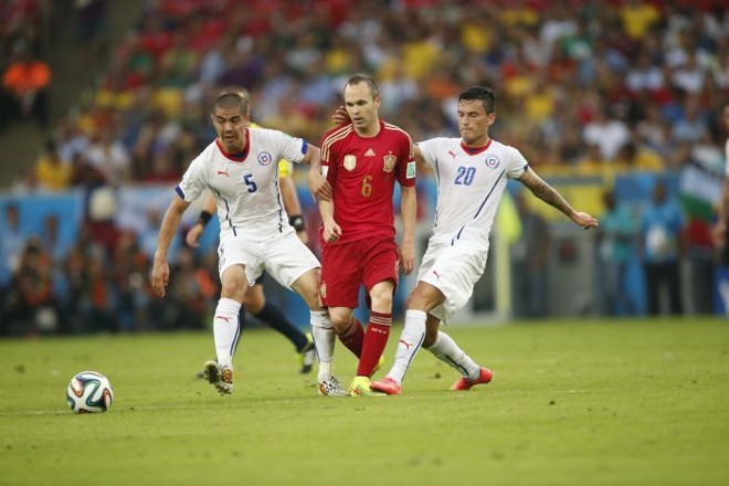 Iniesta sofre forte marcação na partida entre Espanha e Chile |