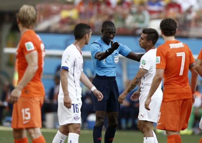 O árbitro Bakary Gassama (centro) adverte o chileno Eduardo Vargas durante partida contra a Holanda | 