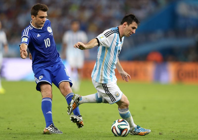 Messi contra o bósnio Zvjezdan Misimovic no jogo deste domingo | Antonio Lacerda/EFE