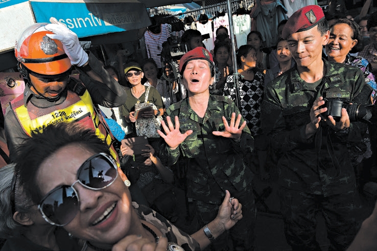 Soldados tailandeses dançam com residentes em um evento organizado pela junta militar | Christophe Archambault/Agence France-Presse Getty Images