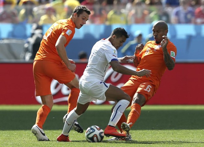 Sanchez (centro), tenta driblar os jogadores da seleção holandesa Nigel De Jong (dir.) e Daley Blind | 