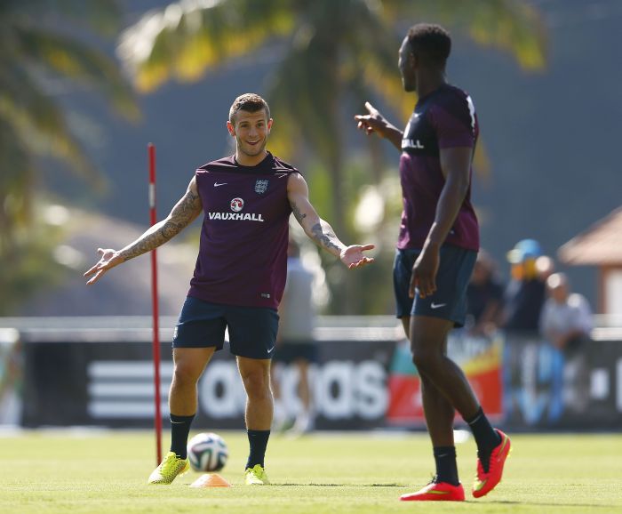 Danny Welbeck, à dir., fala com companheiro de equipe Jack Wilshere. Atacante sentiu lesão na coxa | Reuters