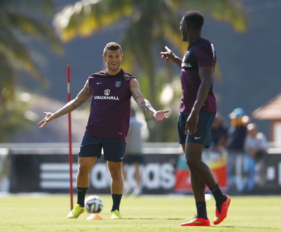 Danny Welbeck, à dir., fala com companheiro de equipe Jack Wilshere. Atacante sentiu lesão na coxa | Reuters