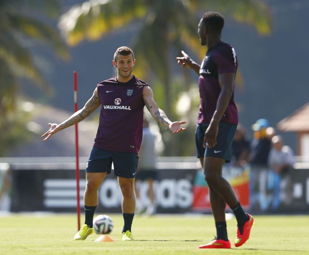 Danny Welbeck, à dir., fala com companheiro de equipe Jack Wilshere. Atacante sentiu lesão na coxa